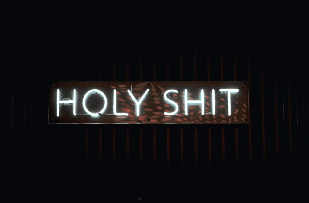 A neon sign that says 'holy shit'